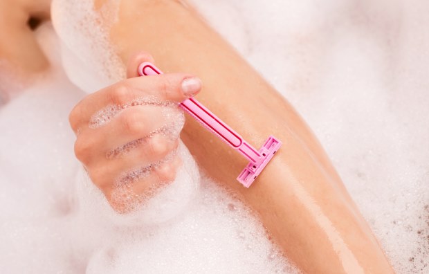 nő borotválkozás fürdés közben