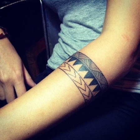 Tatuiruotės apyrankė mergaitėms ant rankos. Tatuiruotė virš alkūnės, tai reiškia, gėlės, nuotrauka