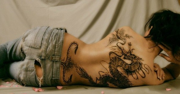 Tatuaże na kręgosłupie (z tyłu) dziewcząt: hieroglify, napisy z tłumaczeniem, kwiaty, kropki, runy, planety, linie. Piękne szkice