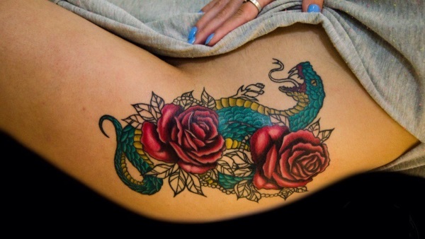 Tetovaže na bedrima za djevojčice: skice, uzorci, natpisi, male tetovaže, cvijeće, životinje, zmajevi, ruže. Fotografija