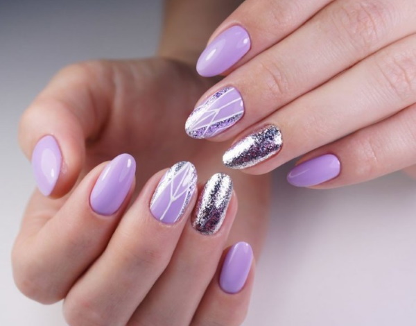 Diseño de uñas de color lila. Foto con pedrería, morado con flores, patrón