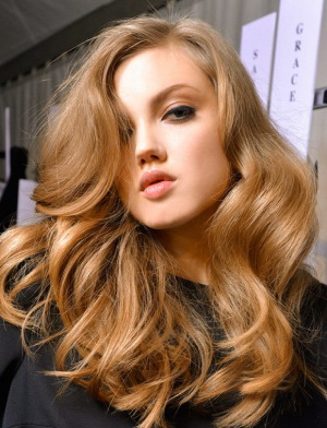 Warme blonde Haarfarbe. Foto mit dunklen Wurzeln, rosa Tönung, Farbe
