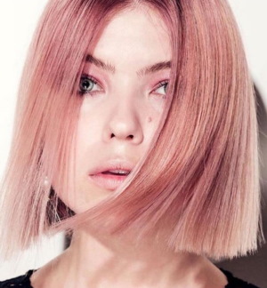 Varm blond hårfärg. Foto med mörka rötter, rosa nyans, färg