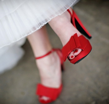 Rote Pediküre an den Füßen.Foto mit Design, Strasssteinen, Mustern, Reiben